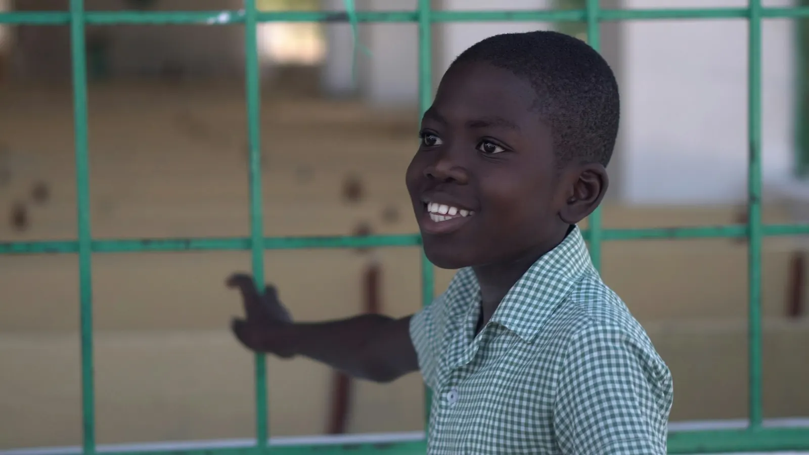 Smiling boy leaning on a fence